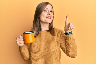 Kafkasyalı güzel bir kadın kahve içiyor bir fikirle gülümsüyor ya da bir soru işareti yapıyor mutlu bir yüzle, bir numara 