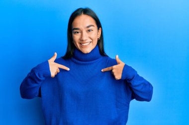 Genç Asyalı kadın, günlük kışlık süveter giyiyor. Kendine güvenen, yüzünde gülümseme olan, kendini gururlu ve mutlu gösteren bir kadın.. 