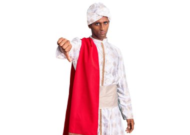 Geleneksel Sherwani sari giysisi giyen Afrikalı yakışıklı adam mutsuz ve kızgın görünüyor. Reddedilmiş ve olumsuz. kötü ifade. 