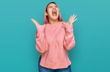 Pembe saçlı İspanyol kadın, sıradan bir kazak giyip başarının çılgınlığını kutluyor. Kolları havada, gözleri kapalı, heyecanla bağırıyor. Kazanan konsept 