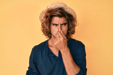 Yaz şapkası takan İspanyol genç adam pis ve iğrenç bir koku alıyor. Nefesini burnunda tutuyor. Kötü kokuyor. 