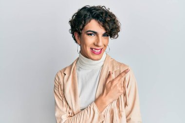 Kadın makyajı yapan genç bir adam ve kadın giysileri. Gülümseyen, el ve parmaklarını kenarda gezdiren neşeli bir adam. 