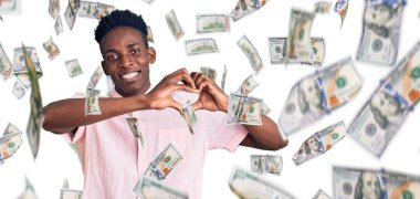 Genç Afro-Amerikalı sıradan kıyafetler giyen, aşık gülümseyen, elleriyle kalp sembolü yapan bir adam. romantik kavram.