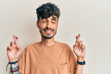 Günlük kıyafetler giyen genç İspanyol adam umut ve gözlerin kapalı gülümseyerek bana işaret etti. Şans ve batıl inançlar. 