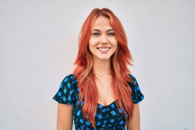 Genç kızıl saçlı kız gülümsüyor Mutlu bir şekilde yürüyor şehrin caddesinde.