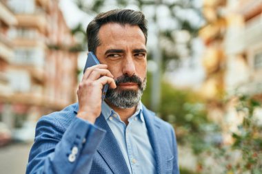 Ciddi bir eski başkan yardımcısı olan orta yaşlı bir işadamı şehirde akıllı telefondan konuşuyor..