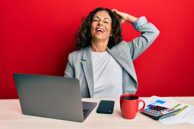 Ofiste çalışan orta yaşlı güzel bir kadın. Bir fincan kahve içiyor. Gülümsüyor, saçlarına dokunuyor, el hareketi yapıyor, çekici ve şık bir poz veriyor. 