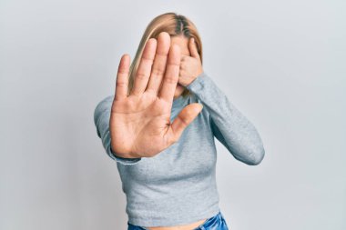 Kafkasyalı genç bir kadın, günlük kıyafetler giyip, elleriyle gözlerini kapatıyor ve üzgün ve korku ifadeleriyle jestleri durduruyor. utangaç ve olumsuz kavram. 