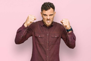 Öfkeli ve kızgın giyinmiş genç İspanyol adam öfkeyle bağırırken kızgın ve öfkeli yumruklar sallıyor. öfke ve agresif konsept. 