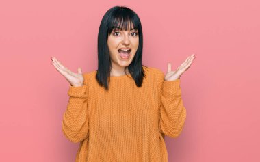 Genç İspanyol kadın gündelik giysiler giyip çılgınlığı kutluyor ve başarıya hayret ediyor. Kolları açık, gözleri açık heyecanla bağırıyor. Kazanan konsept 