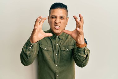 Gündelik kıyafetler giyen genç Latin adam öfkeyle bağırıyor, elleri boğazlamaya çalışıyor, deli gibi bağırıyor. 