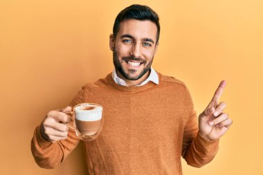 Genç İspanyol adam kahveyi tutarken gülümsüyor. 