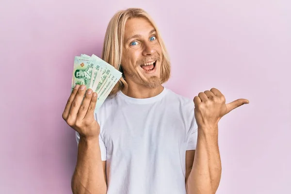 Caucasian Young Man Long Hair Holding Thai Baht Banknotes Pointing — Foto Stock