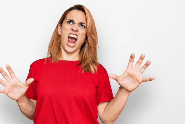 西班牙裔年轻女人穿着宽松的红色T恤 疯狂地喊叫着 带着咄咄逼人的表情和胳膊大喊大叫 沮丧的概念 — 图库照片