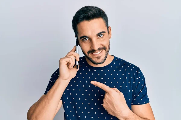Joven Hombre Hispano Conversando Smartphone Sonriendo Feliz Señalando Con Mano — Foto de Stock