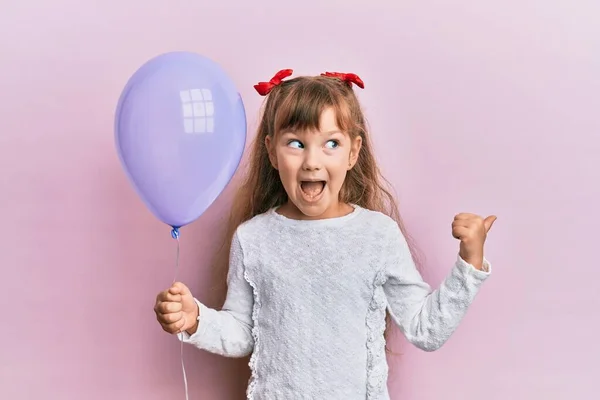 Little Caucasian Girl Kid Holding Purple Balloon Pointing Thumb Side — ストック写真