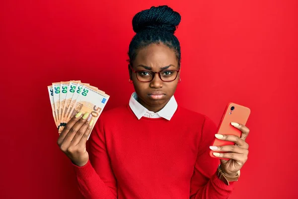 Молода Афроамериканська Жінка Користуючись Смартфоном Тримає Банкноти Євро Скептично Нервово — стокове фото