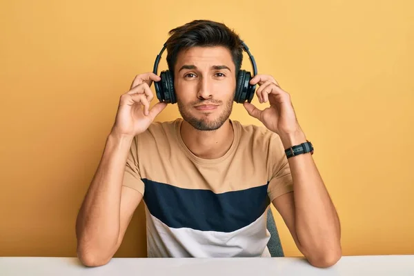 Young Handsome Man Listening Music Wearing Headphones Puffing Cheeks Funny — Stockfoto