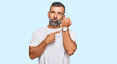 Orta yaşlı beyaz tişört giyen yakışıklı adam acele ediyor. Saati, sabırsızlığı ve rahat bir ifadeyle kameraya bakıyor. 