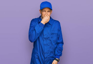 Sakallı, inşaatçı tulumu giyen kel bir adam pis ve iğrenç bir koku alıyor, dayanılmaz bir koku, parmakları burnunda nefesini tutuyor. Kötü kokuyor. 