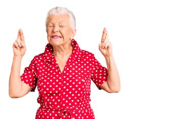 Mavi gözlü, gri saçlı, kırmızı bir elbise giyen, umut ve gözlerin kapalı bir şekilde gülümseyerek el sallayan son sınıf güzeli bir kadın. Şans ve batıl inançlar. 