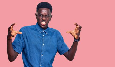 Genç, Afro-Amerikan bir adam günlük giysiler içinde öfkeyle bağırıyor, elleri boğmaya çalışıyor, deli gibi bağırıyor. 