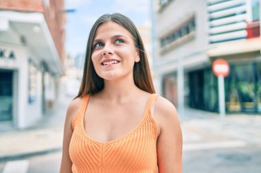 Genç ortadoğu kızı gülümseyerek şehirde mutlu mesut yürüyor..