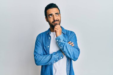 Gündelik kıyafetler giyen genç İspanyol adam şüphe üzerine yoğunlaşmıştı. Parmakları çenesinde ve yukarı bakıyordu. 