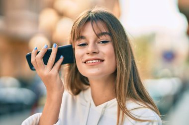 Kafkas sportif genç kız şehirdeki akıllı telefonu kullanarak sesli mesaj dinliyor..