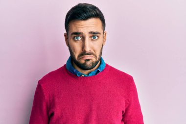 Günlük giysiler giyen genç İspanyol bir adam depresyonda ve sıkıntıdan endişe ediyor, kızgın ve korkmuş bir şekilde ağlıyor. hüzünlü ifade. 