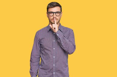 Sıradan kıyafetler ve gözlük takan yakışıklı beyaz adam sessiz olup dudaklarını öpmek istiyor. sessizlik ve gizli konsept. 