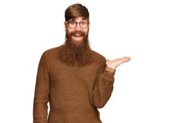 Genç İrlandalı kızıl elbiseli ve gözlüklü, neşeli gülümseyen, avuç içi kadar eli olan ve kameraya bakan adam.. 