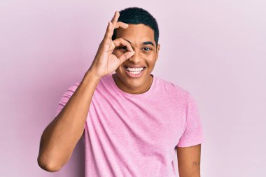 Genç, yakışıklı, pembe tişörtlü bir İspanyol. Tamam, el hareketleriyle gülümsüyor, gözleriyle mutlu yüzle parmaklarının arasından bakıyor.. 