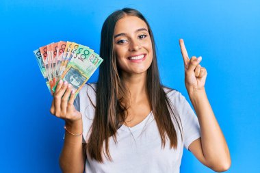 Genç İspanyol kadın elinde bir fikirle ya da soru sorarak gülümseyen bir Avustralya doları tutuyordu. 