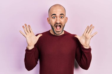 Sıradan kıyafetler giyen genç kel bir adam çılgın ve başarıyı kollarını kaldırıp heyecanla haykırarak kutluyor. Kazanan konsept 