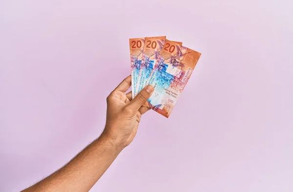 西班牙手拿着20瑞士法郎的钞票和粉红色的背景 — 图库照片