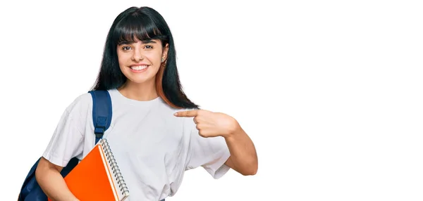 Jovem Hispânico Menina Vestindo Estudante Mochila Segurando Livro Apontando Dedo — Fotografia de Stock