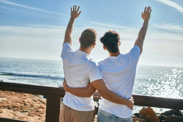 一对年轻的同性恋夫妇在后视镜下眺望海滩上的地平线 — 图库照片