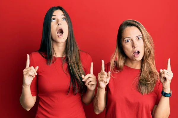 Família Hispânica Mãe Filha Vestindo Roupas Casuais Sobre Fundo Vermelho — Fotografia de Stock