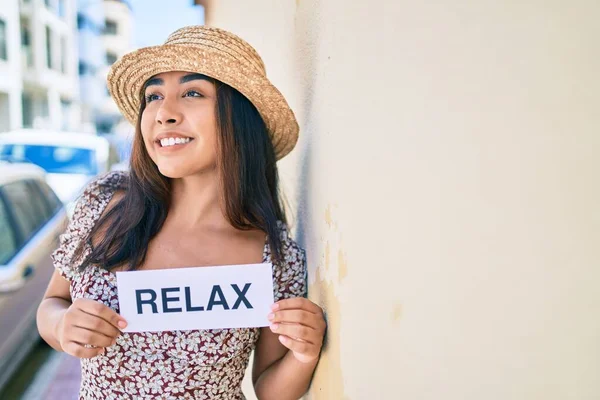 Mujer Latina Joven Vacaciones Sosteniendo Relajarse Papel Palabra Apoyada Pared — Foto de Stock