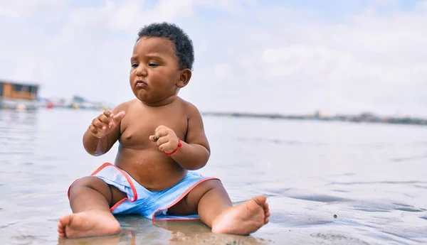 可敬的非洲裔美国幼儿坐在海滩上 — 图库照片