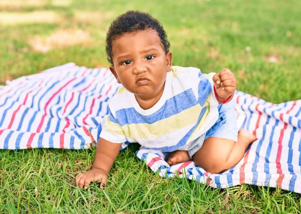 公園で草の上に座っている愛らしいアフリカ系アメリカ人の幼児 — ストック写真