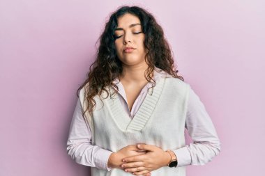 Kıvırcık saçlı genç esmer kadın midesi üstünde gündelik kıyafetler giyiyor çünkü hazımsızlık, acı verici bir hastalık ve kendini iyi hissetmiyor. Ağrı kavramı. 