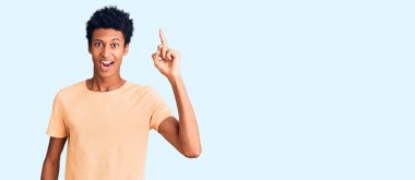 Gündelik giysiler giymiş genç Afro-Amerikan bir adam başarılı bir fikri işaret ediyor. Heyecanlı ve mutlu. Bir numara.. 