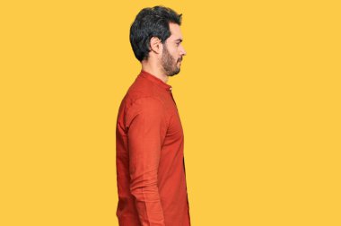 Latin kökenli genç adam rahat bir görünüm takınıyor, rahat bir görünüm takınıyor, kendine güvenen bir gülümsemeyle.. 