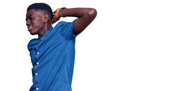 Genç Afrikalı Amerikalı sıradan kıyafetler giyen boyun ağrısı çeken, eliyle boynuna dokunan, kas ağrısı çeken bir adam. 