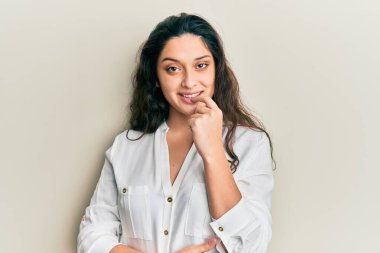 Beautiful middle eastern woman wearing casual clothes looking confident at the camera with smile with crossed arms and hand raised on chin. thinking positive. 