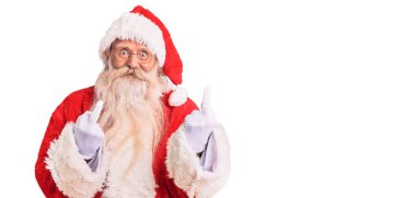 Old senior man with grey hair and long beard wearing traditional santa claus costume showing middle finger doing fuck you bad expression, provocation and rude attitude. screaming excited 