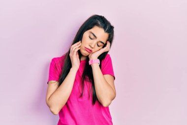 Gündelik pembe tişört giyen genç İspanyol kız. Yorgun eller, yüzü, depresyonu ve üzüntüyü örten, sorun yüzünden üzgün ve sinirli. 