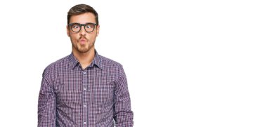 Sıradan kıyafetler ve gözlük takan yakışıklı beyaz adam dudaklarıyla balık suratı yapıyor, çılgınca ve komik bir jest. Komik ifade. 